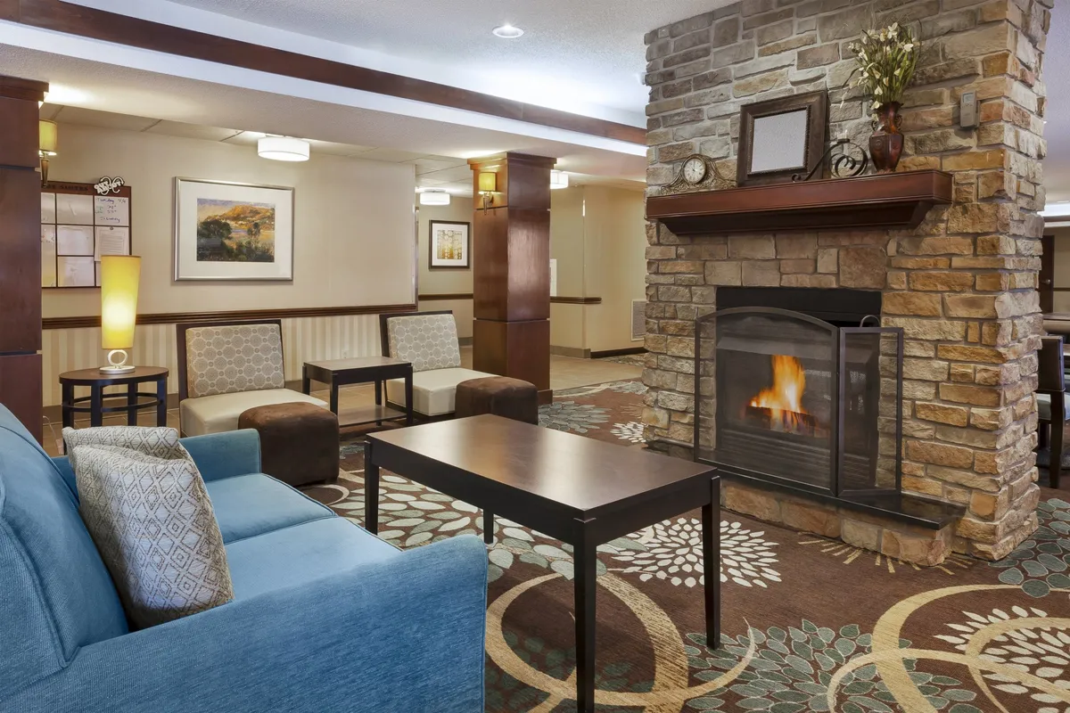 A stylish living room with a comfortable sofa, coffee table, decorative plants, and a fireplace. The atmosphere is cozy and welcoming, ideal for socializing, relaxing, or enjoying personal downtime.